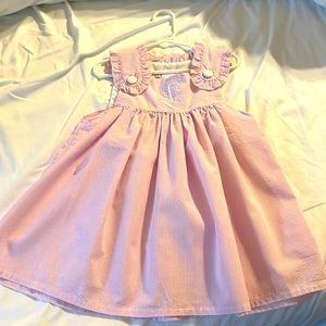Pink seersucker toddler dress with “L” monogram